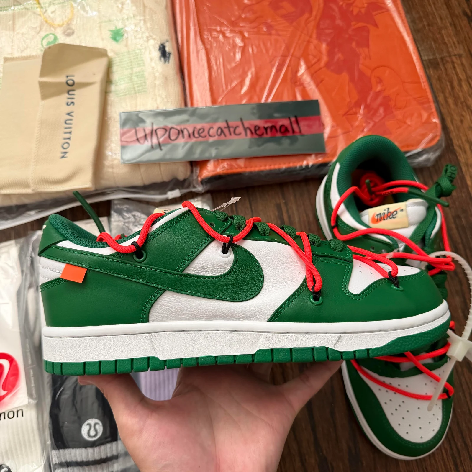 Boczny widok zielono-białego niskiego sneakersa z kontrastowymi pomarańczowymi dodatkowymi sznurówkami.