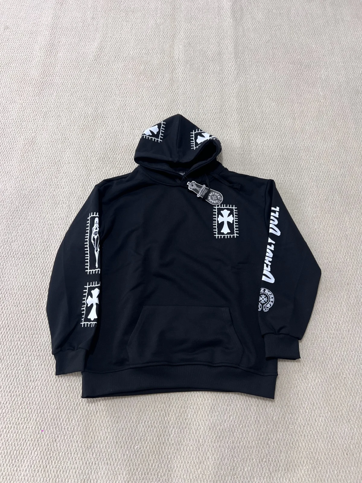Front view of the black hoodie showing chest and sleeve graphics.