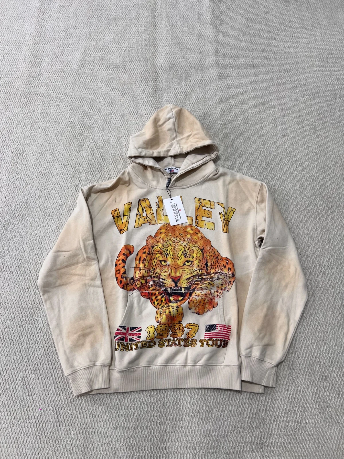 Light-colored pullover hoodie with a large leopard illustration and lettering on the front.