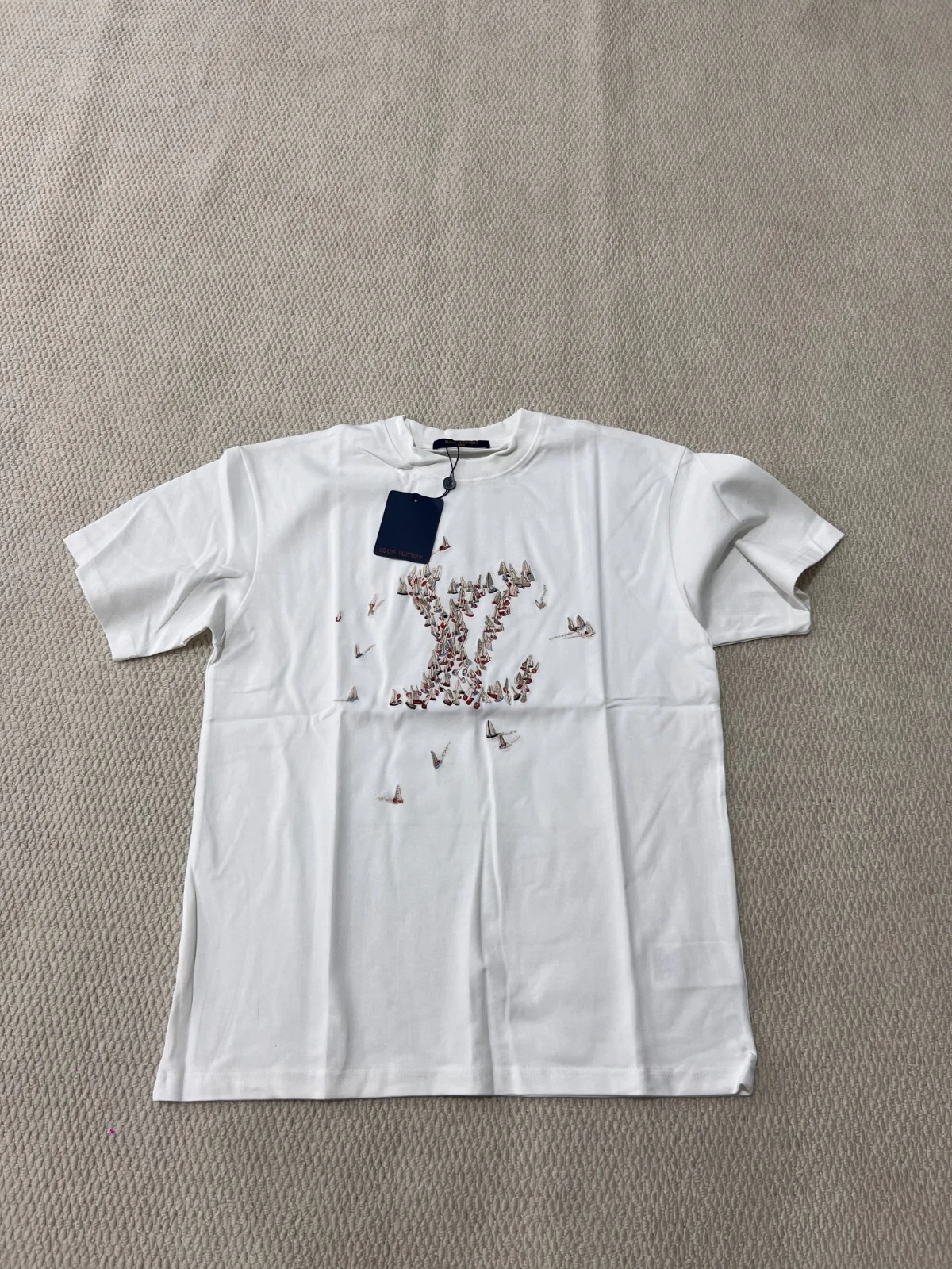 White short-sleeve T-shirt with a bird-shaped chest graphic.