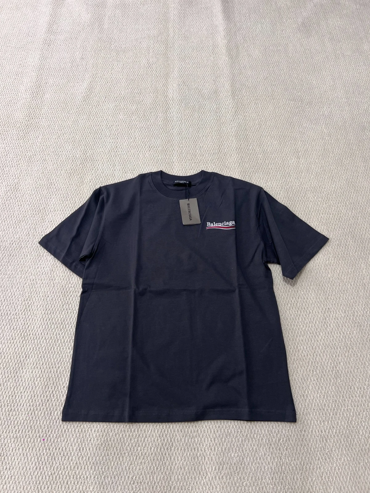 Front view of a dark T-shirt with a small chest logo.