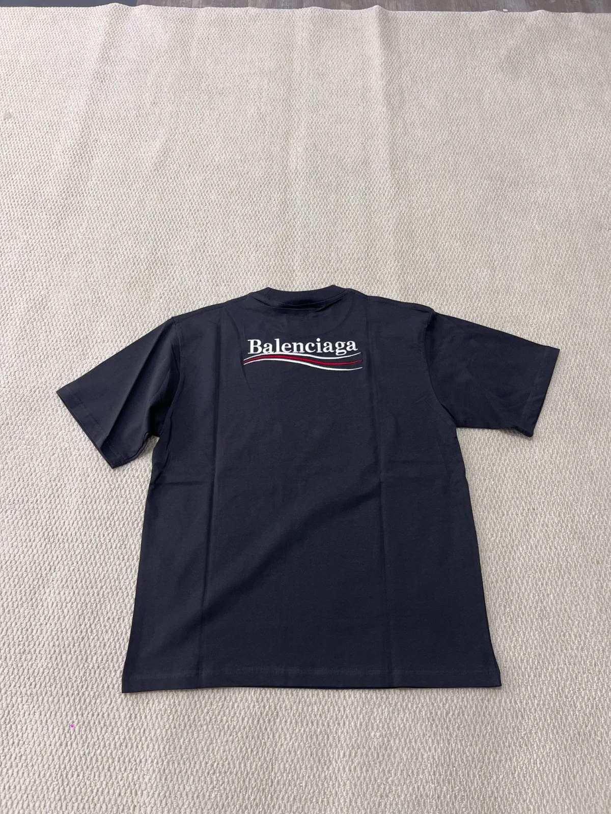 Back view of the dark T-shirt with a larger campaign-style logo.