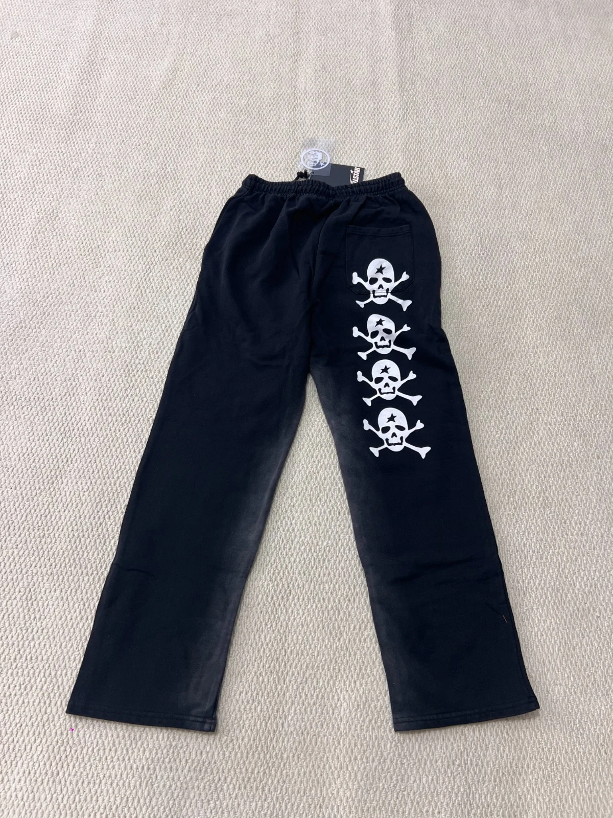 Black trousers with three white skull-and-crossbones motifs down one leg.
